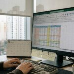 엑셀 스프레드시트 화면과 키보드를 조작하는 책상 환경