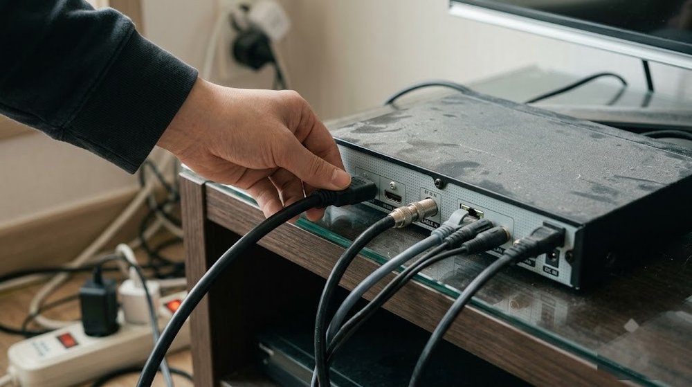 셋톱박스 뒷면 HDMI 케이블 접촉 상태를 점검하는 손